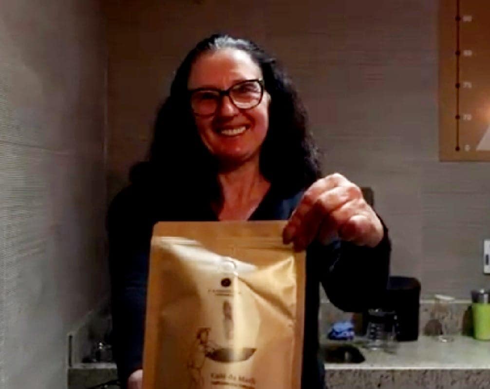 Uma mulher segurando uma embalagem de café