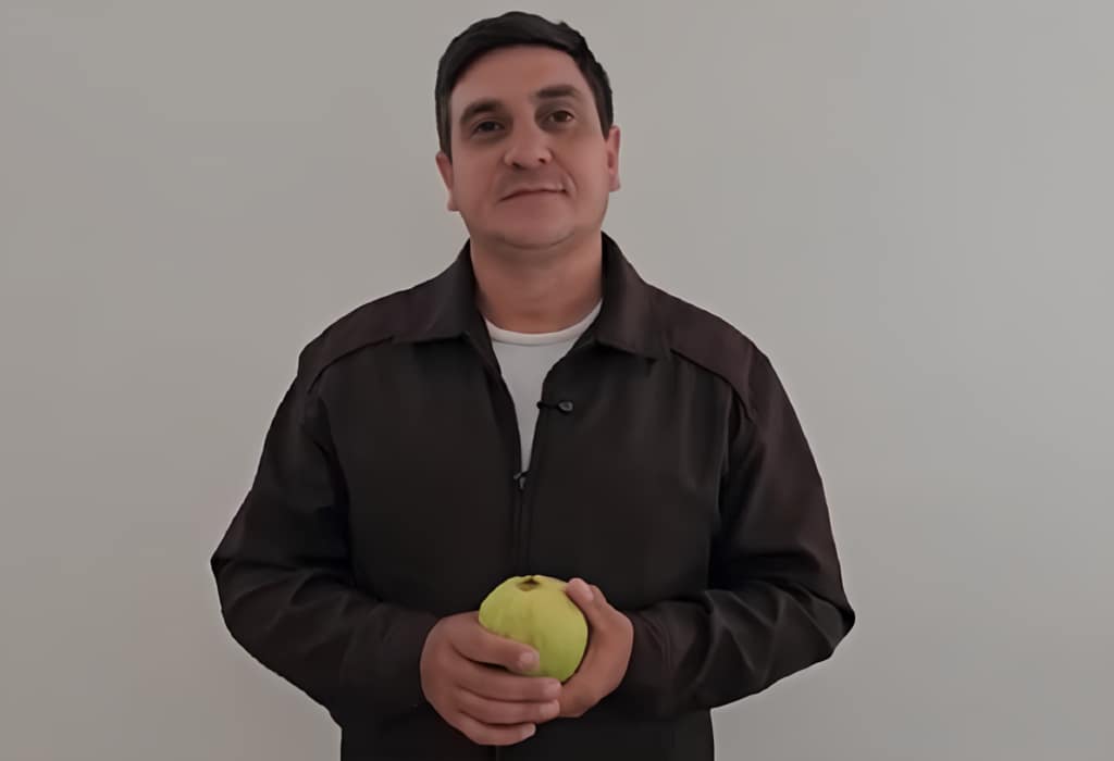 Agricultor segurando uma goiaba.