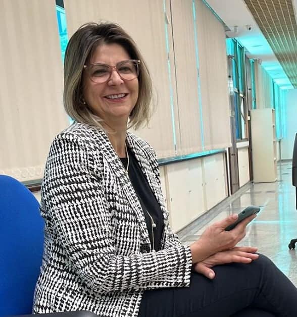 Mulher sentada com o celular nas mãos